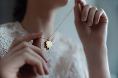 Handmade Jewelry - Woman with golden silhouette pendant in her hands